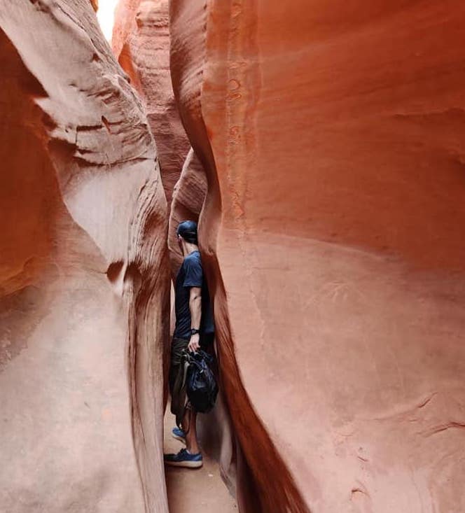 Man walking through Spooky Gulch canyon in Utah